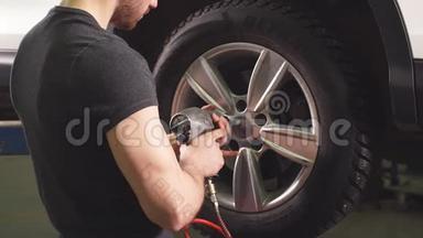 汽车修理厂的汽车修理工在更换车轮。