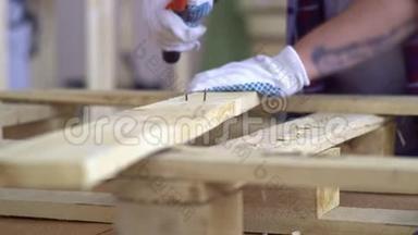 戴白手套的师傅用木制家具。 师傅把钉子钉进木板，然后从木板上取下钉子