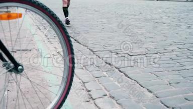 运动员们沿着铺好的路<strong>奔跑</strong>，经过一个骑自行车的人，从自行车的轮子上可以看到<strong>奔跑</strong>的人们，城市