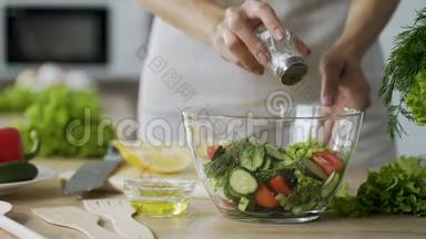 女人在沙拉里<strong>加</strong>盐，在玻璃碗里<strong>加</strong>蔬菜，特写<strong>视频</strong>