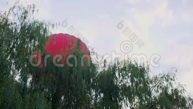 红色热气球飞过树木，休闲活动和运动，极限
