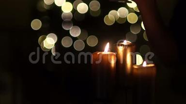 用圣诞灯在黑暗的背景上特写三支蜡烛。 <strong>两杯</strong>红酒，<strong>两杯</strong>庆祝