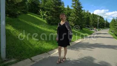 慢动作快乐微笑的年轻女子穿着黑色连衣裙在阳光明媚的公园散步`<strong>夏天</strong>。 慢<strong>节奏</strong>