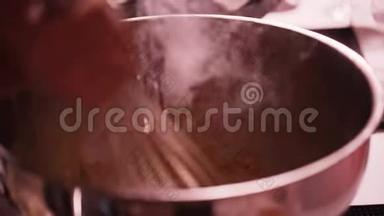 银碗，盛有液态氮的蒸汽，用手搅拌。
