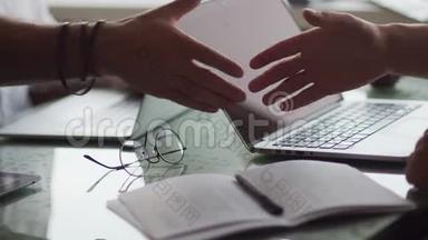 商业概念，桌子上有笔记本电脑，文件，文件，眼镜。 <strong>特写</strong>镜头。 伙伴<strong>握手</strong>