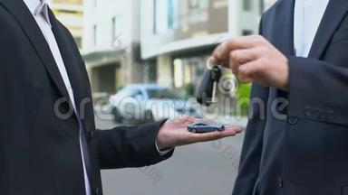 男子拿着新交通工具的钥匙，手里拿着象征意义的玩具车