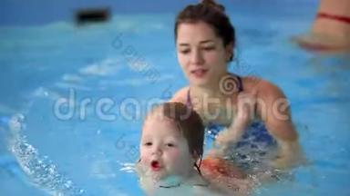 快乐微笑的幼儿在游泳池里跳着，在水<strong>底下</strong>潜水.. 一次水下射击。 慢动作
