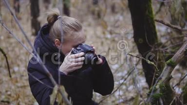 摄影师女孩走在秋木上，拍摄大自然的照片。 第一场雪。 电影镜头。 <strong>慢慢慢慢</strong>