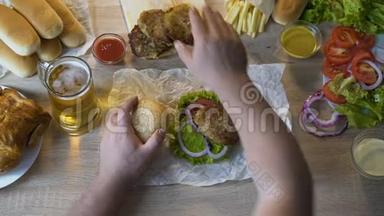 肥胖男人在他的汉堡里添加脂肪炸排，不健康的饮食，俯视图