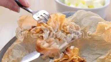 女人正在吃朱莉安烘焙的面团，放在面包纸上，上面有茶和黄油。 双手特写..