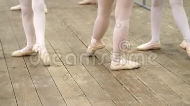 特写镜头，穿着芭蕾<strong>舞鞋</strong>的年轻芭蕾舞演员的腿，穿着米色紧身裤的尖，在巴雷附近做运动，穿着一件旧衣服