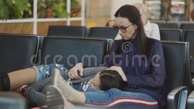 在机场<strong>候机</strong>室里睡在椅子上的母女