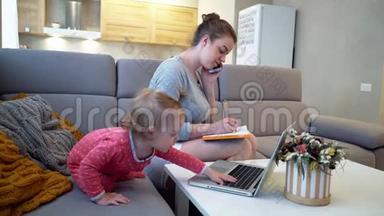 女妈妈在家里和一个婴儿一起用电脑上网
