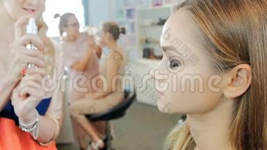 专业化妆师在时装秀前在模特脸上化妆的特写慢镜头
