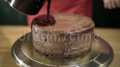 在蛋糕上倒入的液体巧克力。 行动。 融化的液体巧克力在铁架台上的圆形蛋糕上蔓延开来