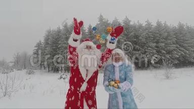 圣诞老人和孙女带着圣诞球在冬天的森林里跳舞。 慢电影画面