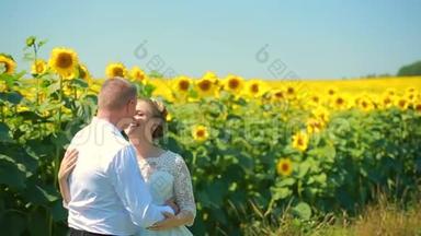 快乐的一对夫妇跑在向日葵的田野上，牵着手微笑。
