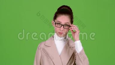 女商人纠正眼镜，对下属生气。 绿色屏幕。 慢动作