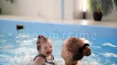快乐微笑的幼儿在游泳池里跳着，在水底下潜水.. 一次水下射击。 慢动作