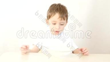 孩子拒绝吃盘子里的食物。 孩子不开心，不想吃东西.. 男孩不喜欢