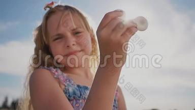 一个年轻明亮的女孩在阳光`的背景下展示一个旋转器。