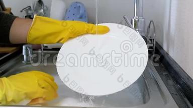 家庭主妇戴黄色橡胶手套在厨房水槽洗碗的特写慢镜头