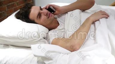 床上男子<strong>接听</strong>电话及智能电话交谈