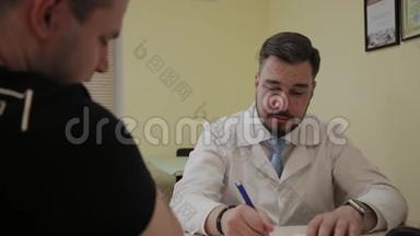 男医生在办公室接诊病人。