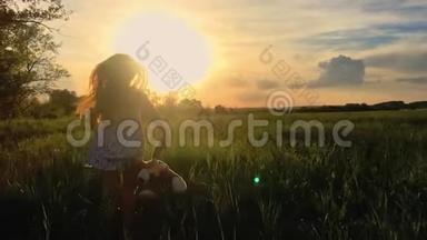 日落后拍摄的可爱少年女孩穿着连衣裙奔跑在绿色草地上。 120英尺，慢速运动。