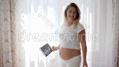 孕妇，孕妇在腹部附近的摄像头上显示婴儿超声波扫描
