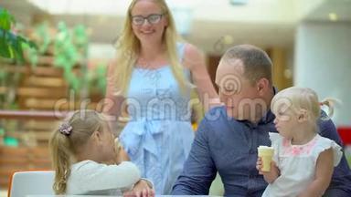 小女孩在大购物中心吃<strong>冰淇淋</strong>和一个喇叭。 家人在商场里吃<strong>冰淇淋</strong>。 家庭幸福。 快乐