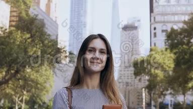 年轻快乐女商人站在美国纽约金融中心公园拿着文件的画像