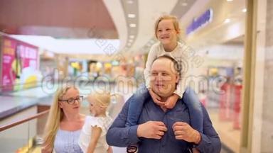 快乐的四口之家在购物。 在<strong>商场</strong>里的家人。 孩子们在购物<strong>中</strong>心和父母在一起。 家庭购物在大商店。 A.