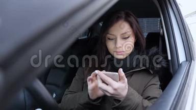 坐在车里用智能手机发短信的女人