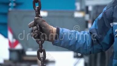 工人在修理工作中触摸起重机吊钩到回路上。 剪辑。 工人保持起重机的链条