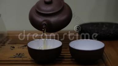 人们把茶壶里的茶倒进碗里. 中国茶道仪式