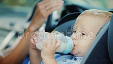 婴儿1岁时喝一瓶牛奶。 坐在<strong>儿童座椅</strong>上
