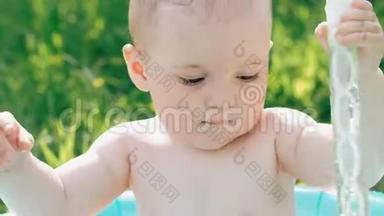 一个阳光明媚的夏天，小男孩在充气游泳池里玩耍