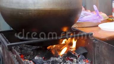 食物在巨大的大锅里沸腾，燃烧着，传统的露天烹饪