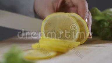 女人在砧板上切柠檬。 手切片柠檬在砧板特写..