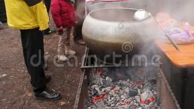 难民们在炉火旁取暖，等待<strong>热汤</strong>准备晚餐