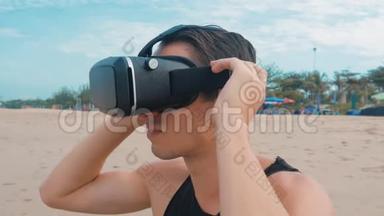 年轻人在海滩上使用虚拟现实眼镜。 在夏季旅游中使用VR耳机的人获得了经验