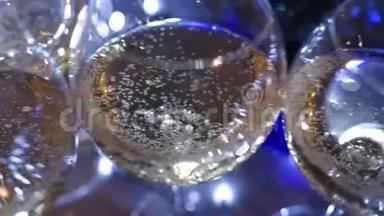 在圣诞灯光背景下的桌子上放着香槟或葡萄酒的漂亮眼镜。