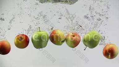 五颜六色的苹果掉在水里溅起水花，滴在干净的白色背景上