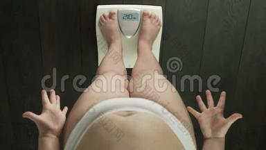 肥胖的女人站在浴室秤上，检<strong>查</strong>体<strong>重</strong>，焦虑，俯视
