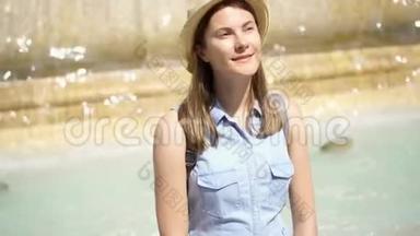 快乐的游客戴着帽子坐在老黄的喷泉上，水流不息。 欧洲度假的女孩