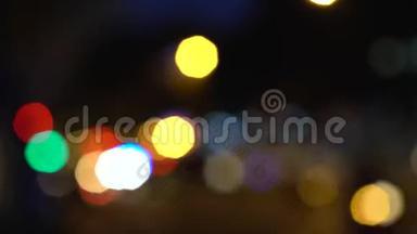 夜间在城市街道上的汽车、滑板车、摩托车和交通工具的散焦或软焦灯光