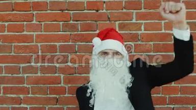 像圣诞老人一样的人在跳舞，圣诞快乐，2019年新年，红砖墙作为背景