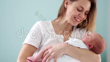 一个新生婴儿在母亲`怀里。 妈妈和她的孩子。 母亲节。 轻轻地抚摸着她孩子的头。 慢慢