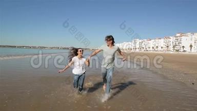 有趣的夫妇和白种人<strong>一起跑</strong>步。 他们有很多乐趣。 海在背景上。